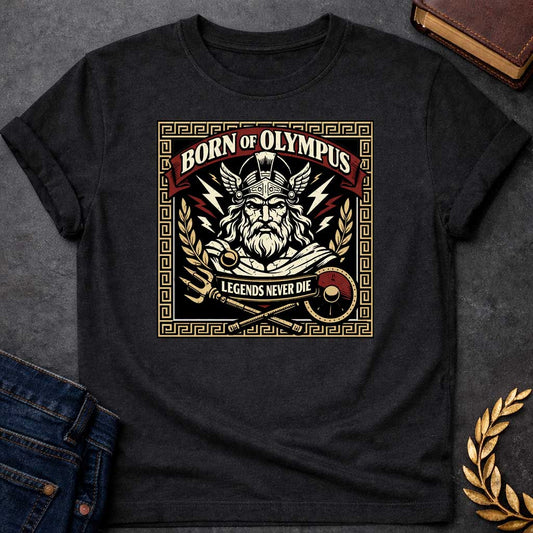 Black T-shirt graphic featuring a bold vintage label-style design with a Greek meander border in gold. A red arched banner at the top reads "Born of Olympus" above a front-facing illustration of Zeus with long white hair and beard wearing a winged helmet, surrounded by radiating lightning bolts and flanked by golden laurel branches. A crossed trident and scepter with a red shield sit below, with a scroll banner reading "Legends Never Die," rendered in black, gold, cream, and red tones