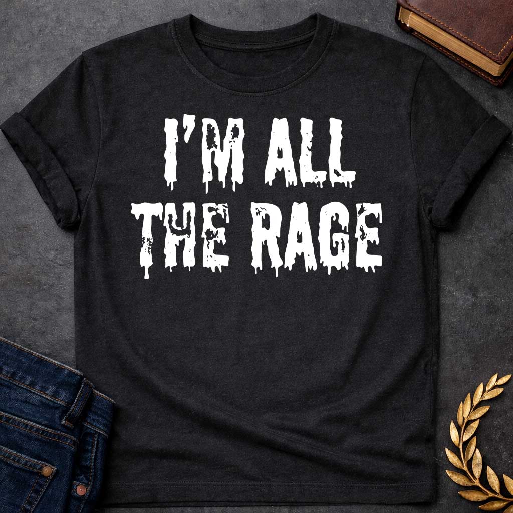 Black T-shirt graphic in white featuring large dripping horror-style text reading "I'm All the Rage" — a double entendre playing on both popular trends and the furious wrath of Ares, the Greek God of War, rendered in a distressed melting font