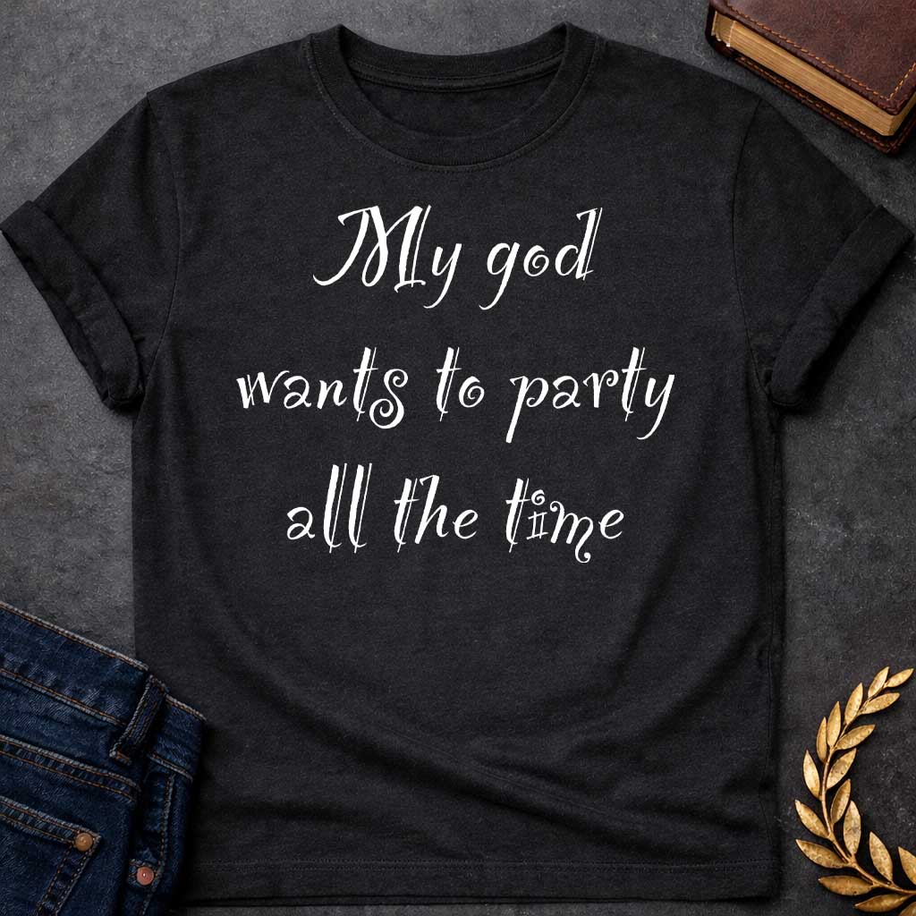 Black T-shirt graphic white text featuring whimsical hand-lettered calligraphy-style text reading "My god wants to party all the time" — a humorous nod to Dionysus, the Greek God of Wine and Revelry