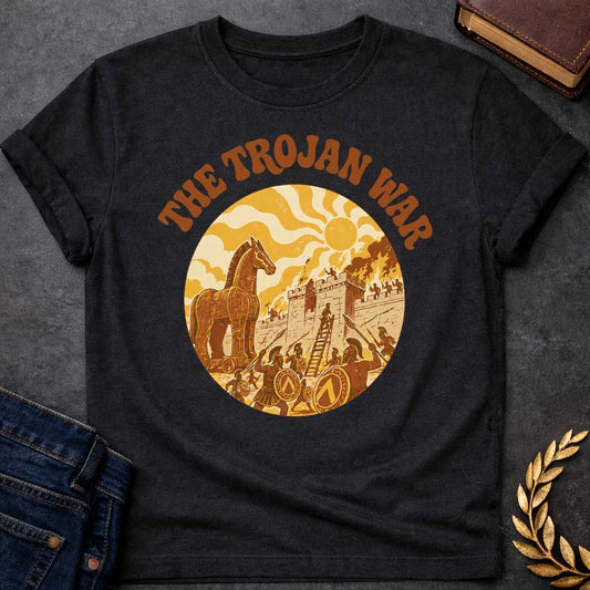 Black T-shirt featuring bold groovy 1970s-style arched brown text reading "The Trojan War" above a circular vintage illustration depicting the siege of Troy — the Trojan Horse stands to the left while Greek warriors with Spartan shields and spears storm the burning walls of Troy using a ladder, under a stylized wavy sun, rendered in a warm retro palette of golden yellow, burnt orange, and brown tones