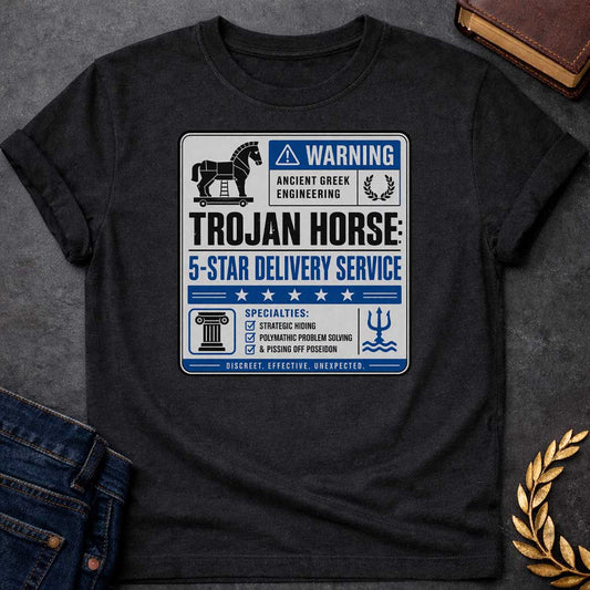 Black T-shirt with a graphic designed as a humorous official-style warning sign in grey, blue, and black featuring a flat Trojan Horse icon with a blue warning triangle and the text "Warning — Ancient Greek Engineering" and a laurel wreath in the top section. Bold text reads "Trojan Horse: 5-Star Delivery Service" above a blue five-star rating banner. A checklist below under "Specialties:" reads "Strategic Hiding, Polymathic Problem Solving, & Pissing Off Poseidon" flanked by a Greek column icon and a Posei