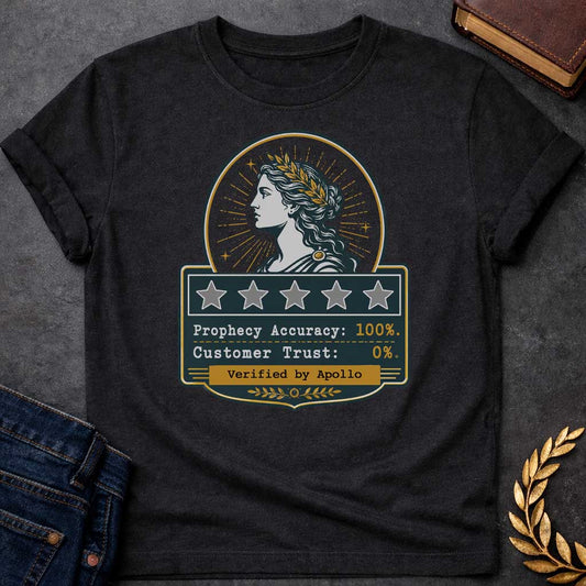 Black T-shirt with a satirical Greek mythology badge referencing Cassandra. The top features a vector profile of a woman wearing a gold laurel wreath with a radiant sunburst behind her. Below, a dark plaque displays five empty review stars. The text reads: "Prophecy Accuracy: 100%." and "Customer Trust: 0%." in a typewriter font. A gold banner at the bottom is stamped with "Verified by Apollo."