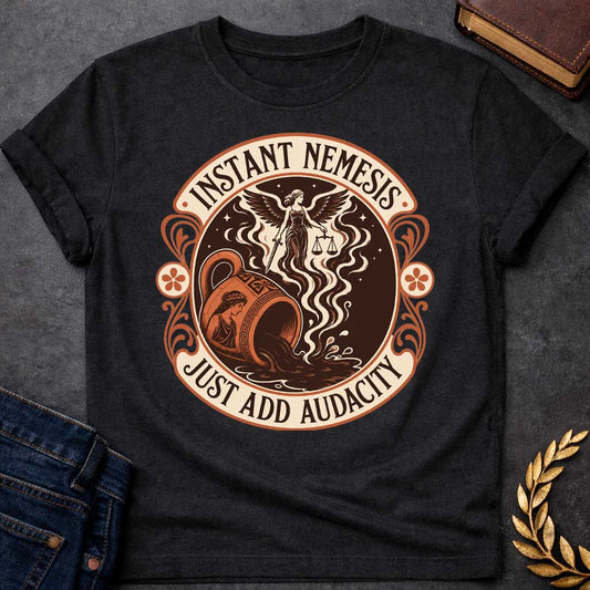 Black T-shirt with a Vintage product-label style circular design in terracotta, cream, and dark brown. Text reads 'INSTANT NEMESIS' at top and 'JUST ADD AUDACITY' at bottom. Center features Nemesis, the winged Greek goddess of retribution, holding scales of justice above a spilling Greek vase with a classical Greek warrior profile. Swirling smoke rises from the vessel. Ornate Art Nouveau flourishes and floral medallions frame the design. Humorous take on Greek mythology and divine consequences.