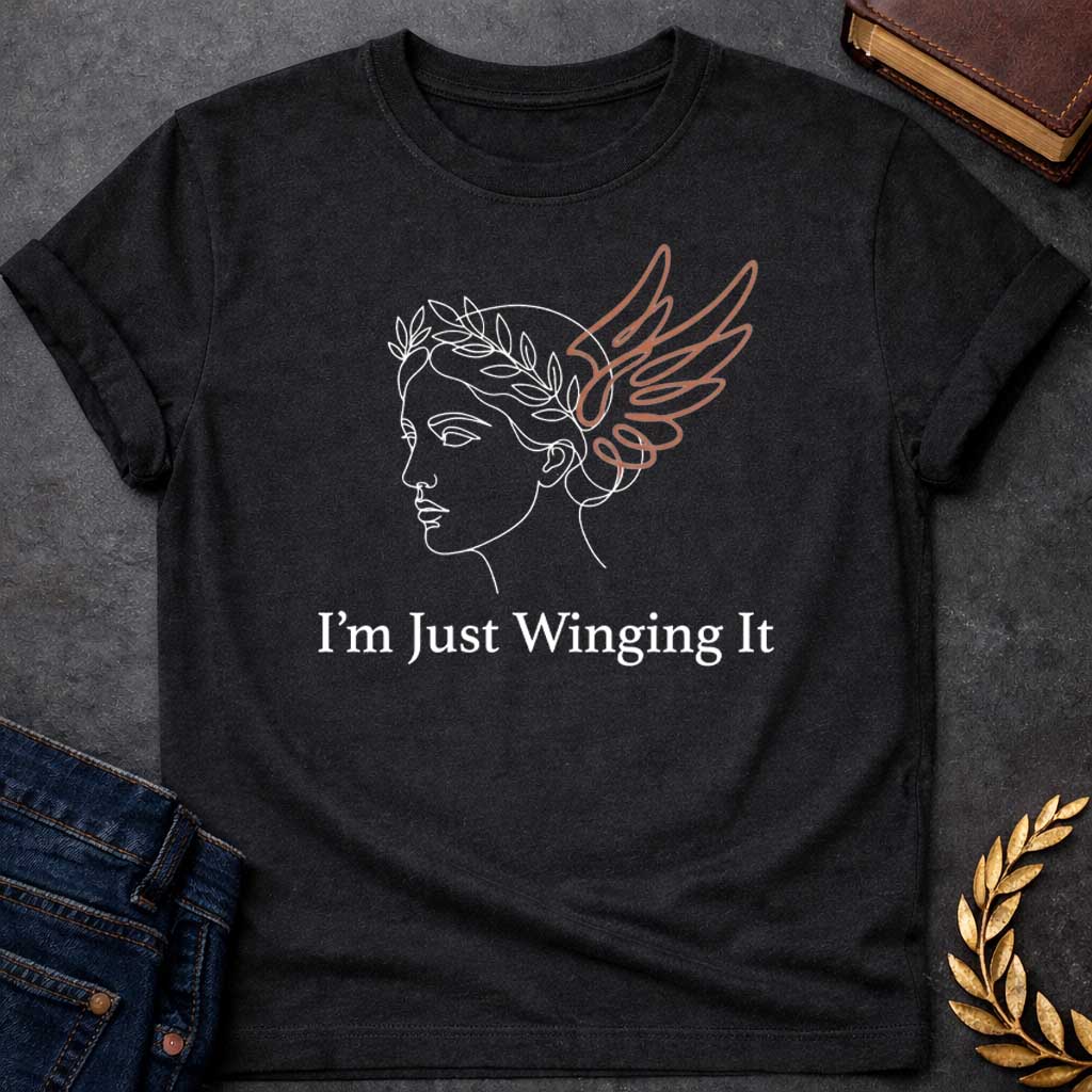 Black T-shirt with a Minimalist line art illustration of a classical Greek profile with a laurel wreath crown and large terracotta-colored wings extending from the head. Elegant continuous line drawing style. Text reads 'I'm Just Winging It' in serif font below. References Nike, the goddess of victory, with a humorous modern spin. Blends classical mythology with relatable contemporary humor about improvisation and navigating life without a plan.