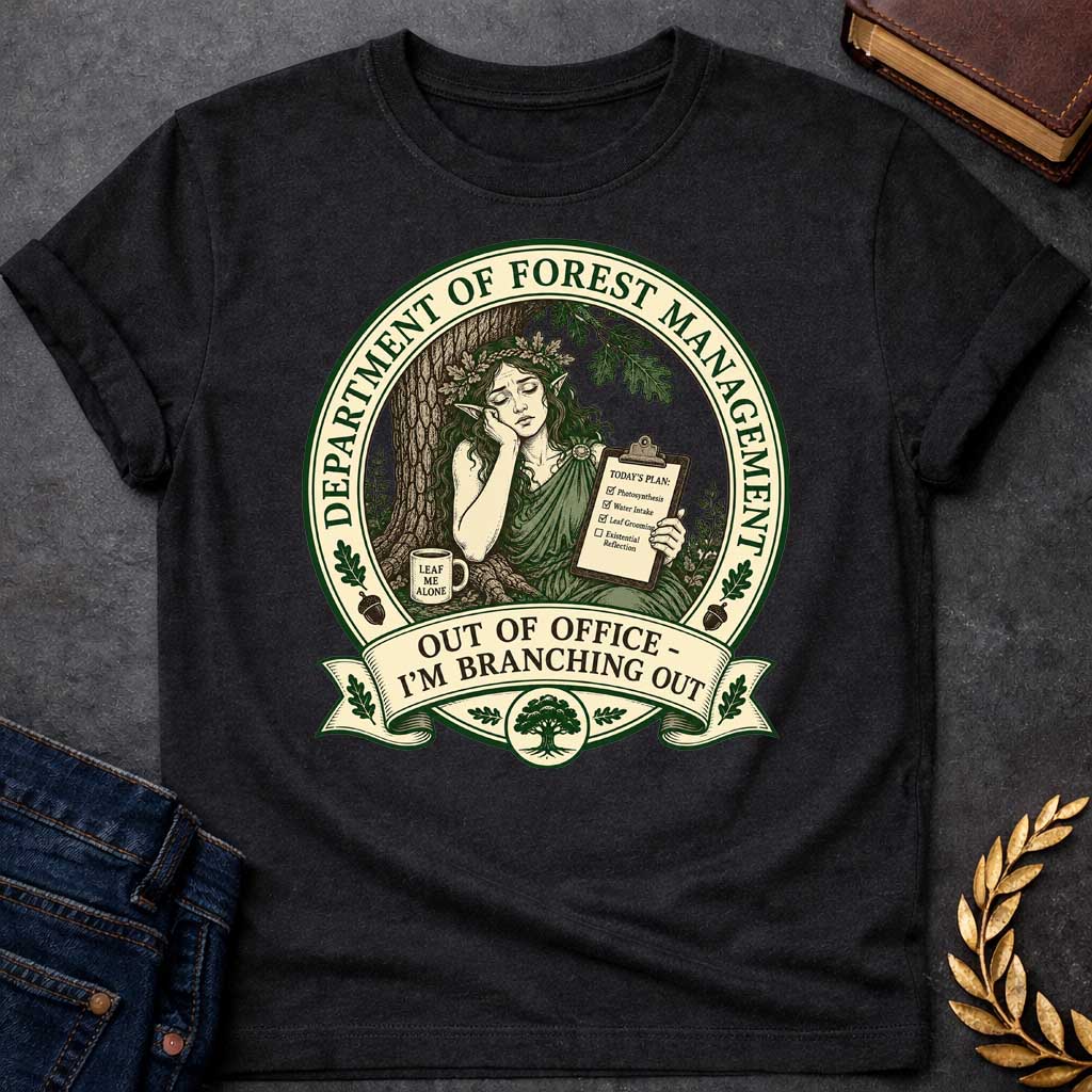 Black T-shirt with a Humorous official seal depicting a forest goddess managing her day. A woman with long hair and oak leaf crown leans against a tree trunk holding a clipboard listing "Photosynthesis," "Water Intake," "Leaf Grooming," and "Existential Reflection." A mug reads "Leaf Me Alone." Surrounded by oak leaves and acorns. Text reads "Department of Forest Management" and "Out of Office - I'm Branching Out." Green and cream design celebrates nature and forest wisdom.