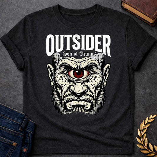 Black T-shirt with a Bold typography design featuring a single-eyed Titan face with fierce expression. Thick white beard and long flowing hair frame a menacing red eye with intense gaze. Black and white engraving style with intricate line work emphasizing the character's otherworldly nature. Text reads 'OUTSIDER' and 'Son of Uranus' referencing the Titans of Greek mythology. Celebrates mythological outsider status, divine rebellion, and powerful, untamed forces beyond mortal comprehension.