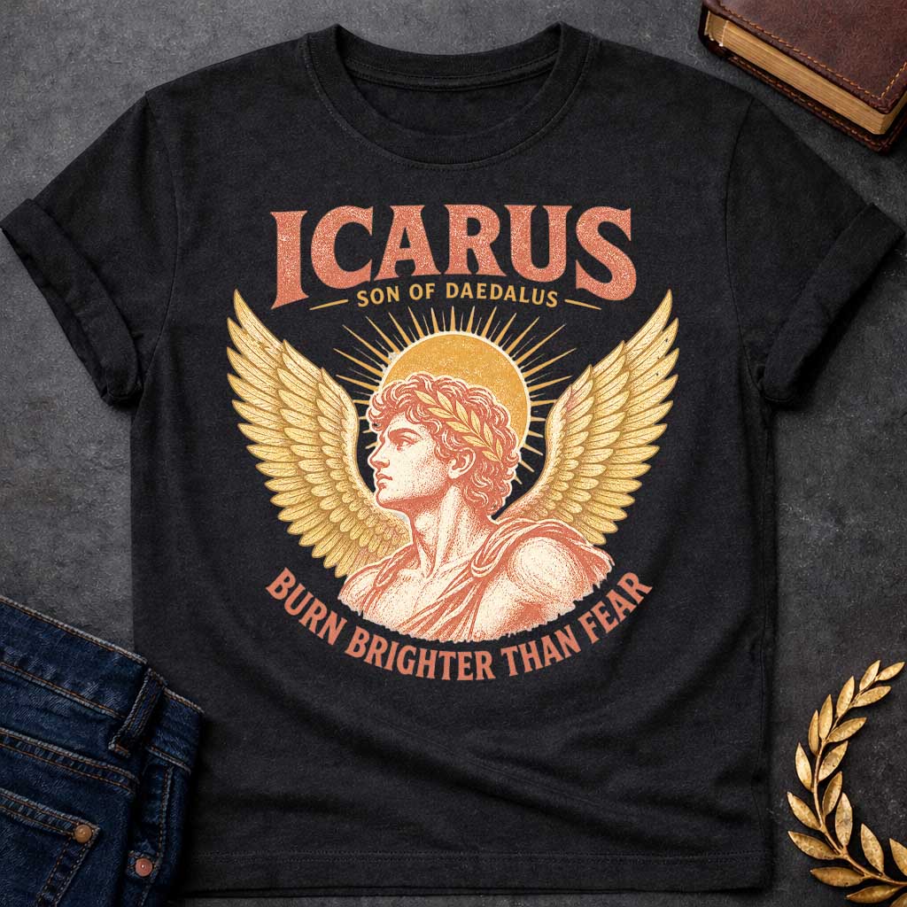Black t-shirt with a Vintage Icarus Greek mythology design featuring the son of Daedalus in profile with large golden wings, a laurel crown, and a radiant sun behind him. Distressed coral and gold artwork gives the design an antique classical look, with bold text reading “Icarus Son of Daedalus” and “Burn Brighter Than Fear.”