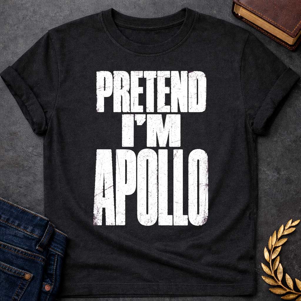 Black t-shirt with a Pretend I’m Apollo Greek mythology design featuring bold distressed white typography on a transparent background. The stacked text reads “PRETEND I’M APOLLO” in a rugged vintage block font, creating a simple humorous design inspired by Apollo, the Greek god of the sun, music, poetry, prophecy, and healing.