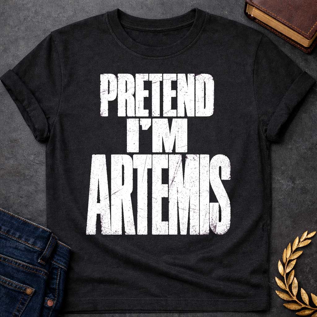 Black t-shirt with a Pretend I’m Artemis Greek mythology design featuring bold distressed white typography on a transparent background. The stacked text reads “PRETEND I’M ARTEMIS” in a rugged vintage block font, creating a humorous design inspired by Artemis, the Greek goddess of the hunt, wilderness, wild animals, archery, and the moon.