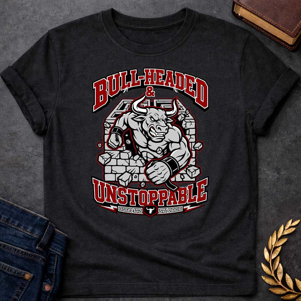 Black T-shirt with a High-impact sports design featuring a muscular Minotaur bursting through a crumbling stone wall in red, gray, and white. The aggressive bull-headed figure displays defined musculature and determination. Text reads 'Bull-Headed & Unstoppable' in bold red and black lettering. Greek key pattern and bull symbol anchor the bottom. Combines Greek mythology with modern gym and sports culture, celebrating stubborn strength and unstoppable power.