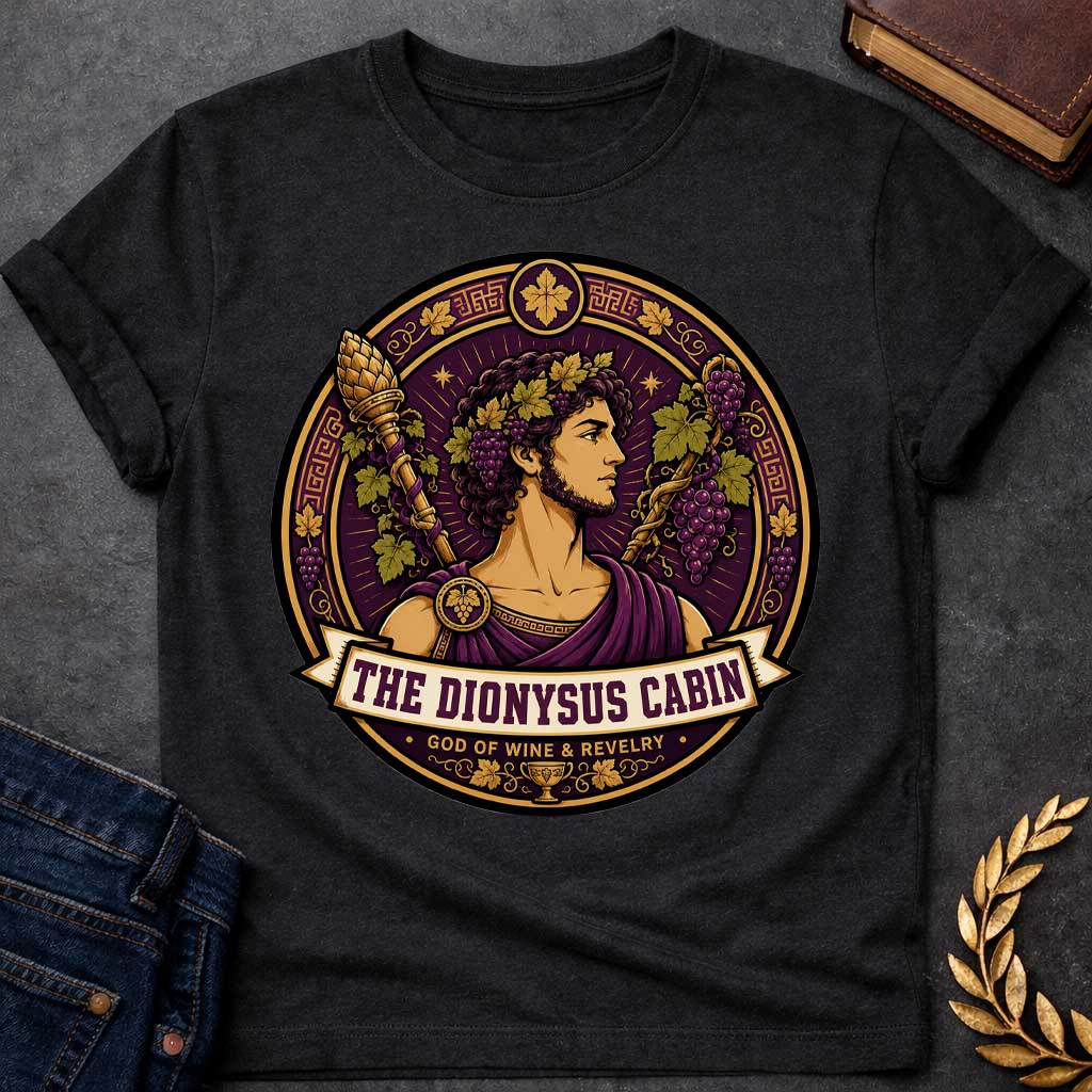 Black t-shirt with a Dionysus Greek mythology cabin design featuring the god of wine and revelry wearing a grapevine crown and purple robes, surrounded by clusters of grapes, vine leaves, a thyrsus, Greek key patterns, and a wine cup. Purple and gold circular emblem includes the text “The Dionysus Cabin” and “God of Wine & Revelry,”