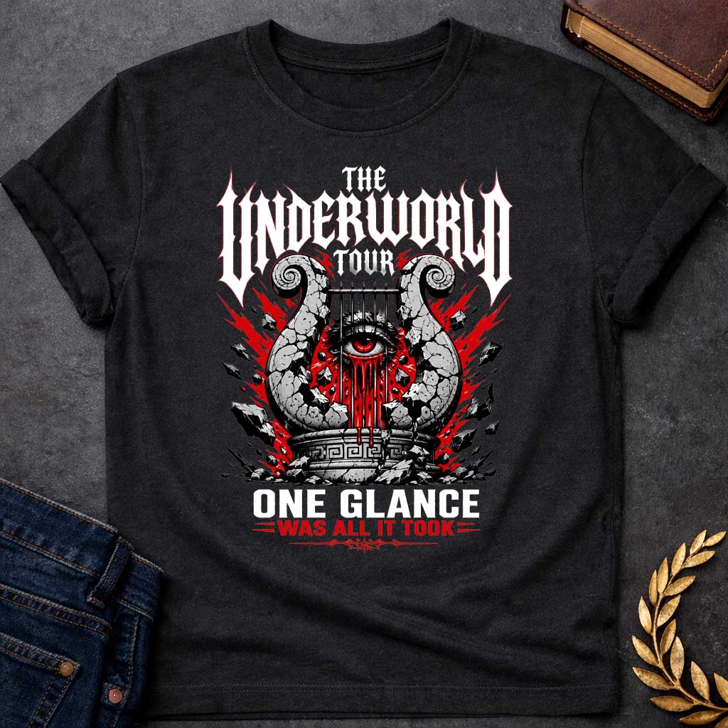 Black t-shirt in heavy metal band-poster style: a cracked stone lyre with a bleeding red eye at its center sits atop a Greek pedestal, framed by jagged red lightning bolts and scattered rubble. Gothic spiked white lettering and bold red accent text complete the design