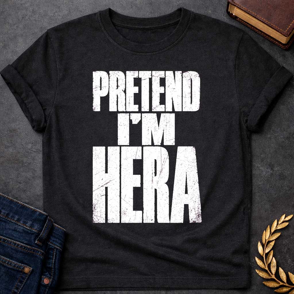 Black t-shirt with a Pretend I’m Hera Greek mythology design featuring bold distressed white typography on a transparent background. The stacked text reads “PRETEND I’M HERA” in a rugged vintage block font, creating a humorous design inspired by Hera, the Greek goddess of marriage, women, family, and queen of the Olympian gods.