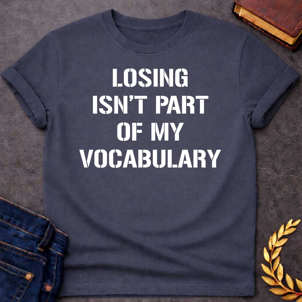Dark Heather Black T-shirt graphic in white featuring bold military stencil-style text reading "Losing Isn't Part of My Vocabulary" — a motivational phrase referencing Ares, the Greek God of War