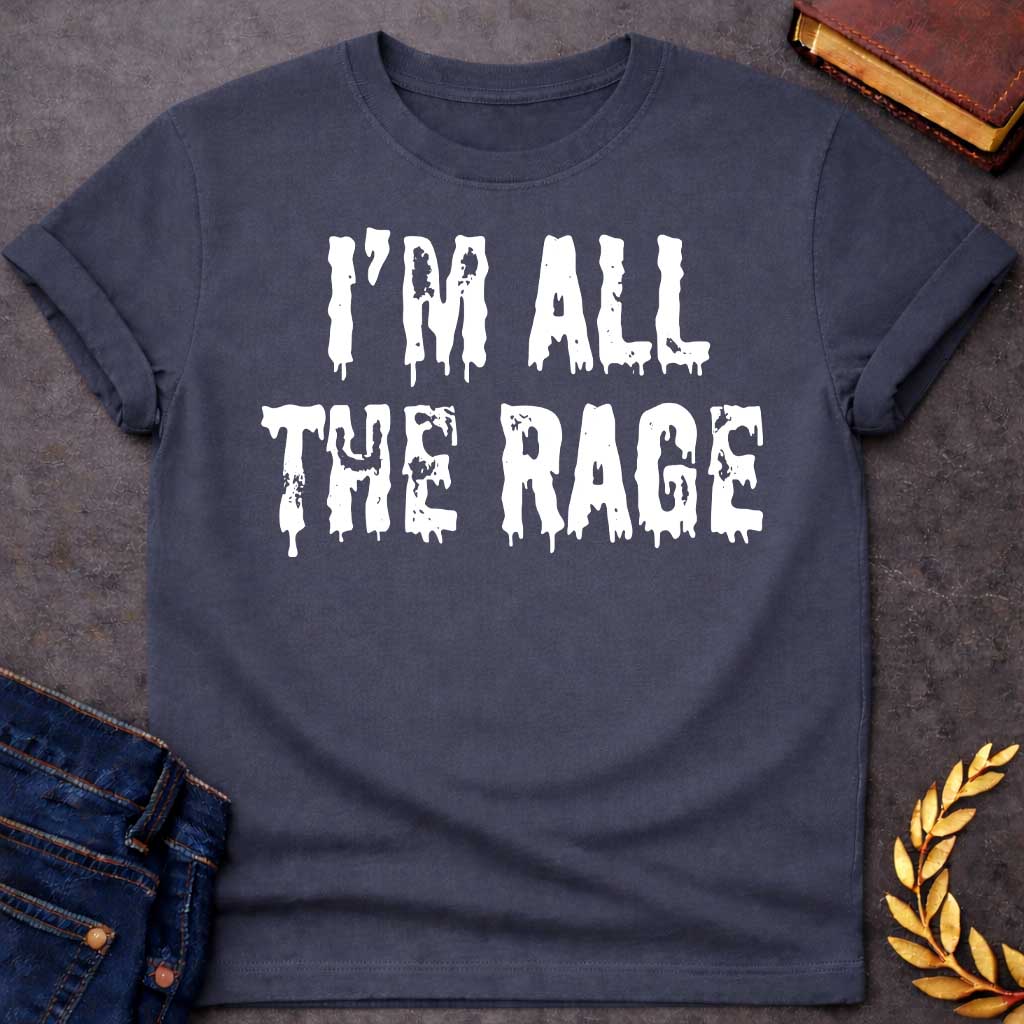 Dark Heather T-shirt graphic in white featuring large dripping horror-style text reading "I'm All the Rage" — a double entendre playing on both popular trends and the furious wrath of Ares, the Greek God of War, rendered in a distressed melting font
