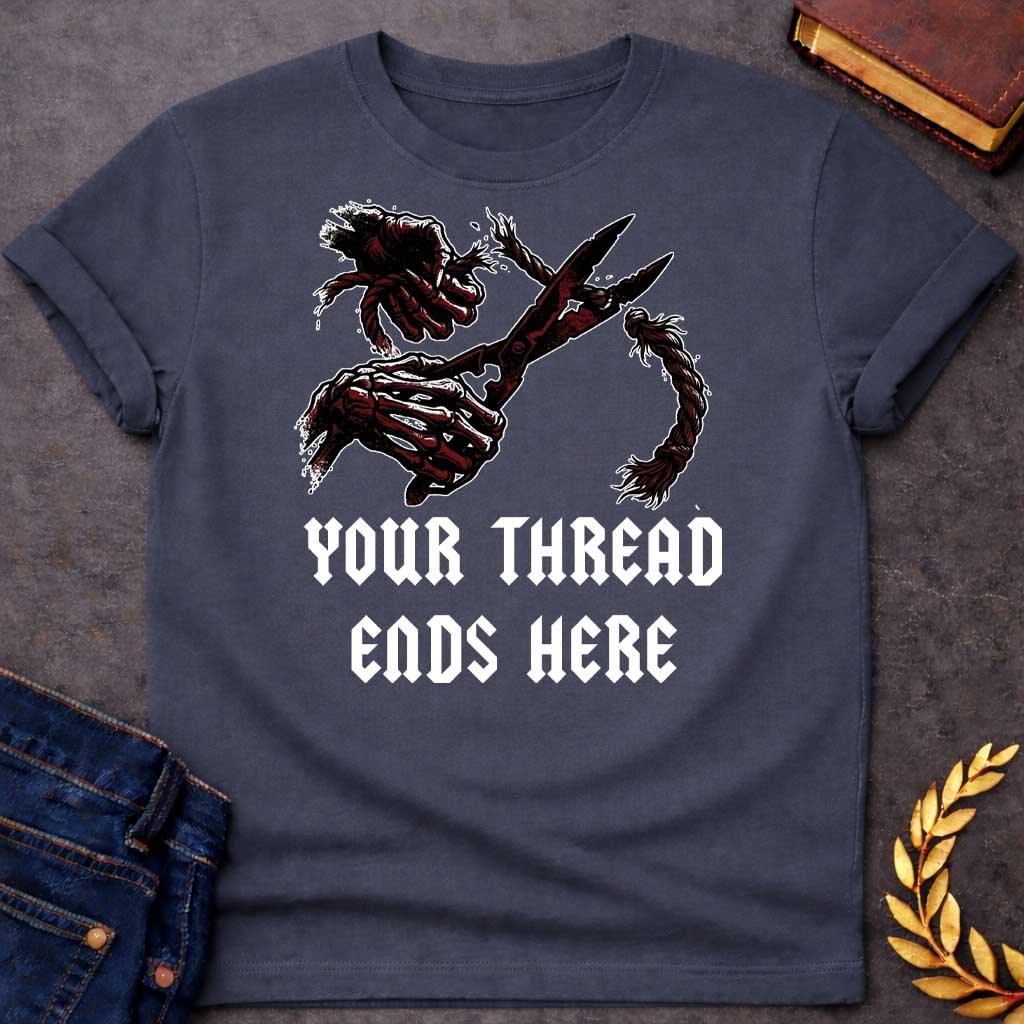 Dark Heather T-shirt graphic in black, white, and dark red featuring a dark illustrated scene of two skeletal hands gripping large shears cutting through a thick fraying rope or thread, rendered in a gritty horror-influenced ink style with ink splatter details. Bold heavy metal-style blackletter text below reads "Your Thread Ends Here" — a dark and dramatic reference to Atropos, the eldest of the Moirai, the Greek Fate who cuts the thread of life