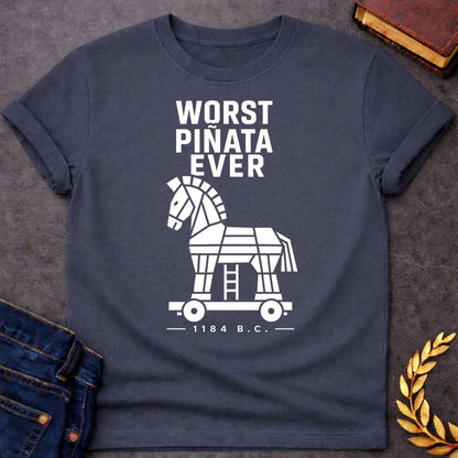 Dark Heather T-shirt with a graphic in white featuring bold condensed sans-serif text reading "Worst Piñata Ever" above a detailed flat geometric white silhouette illustration of the Trojan Horse on a wheeled platform with a visible ladder underneath, with a small datestamp below reading "— 1184 B.C. —" — a humorous reference to the Greek legend of the Trojan War