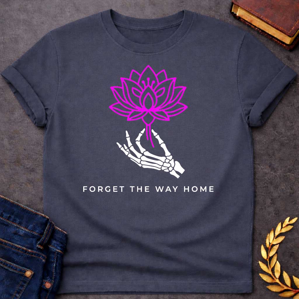 Dark Heather T-shirt with a graphic featuring a bold magenta line-art lotus flower held delicately by a white skeletal hand, with spaced bold sans-serif text below reading "Forget the Way Home" — a darkly humorous reference to the Land of the Lotus-Eaters episode in Homer's Odyssey, where Odysseus's crew ate lotus flowers and forgot their desire to return home