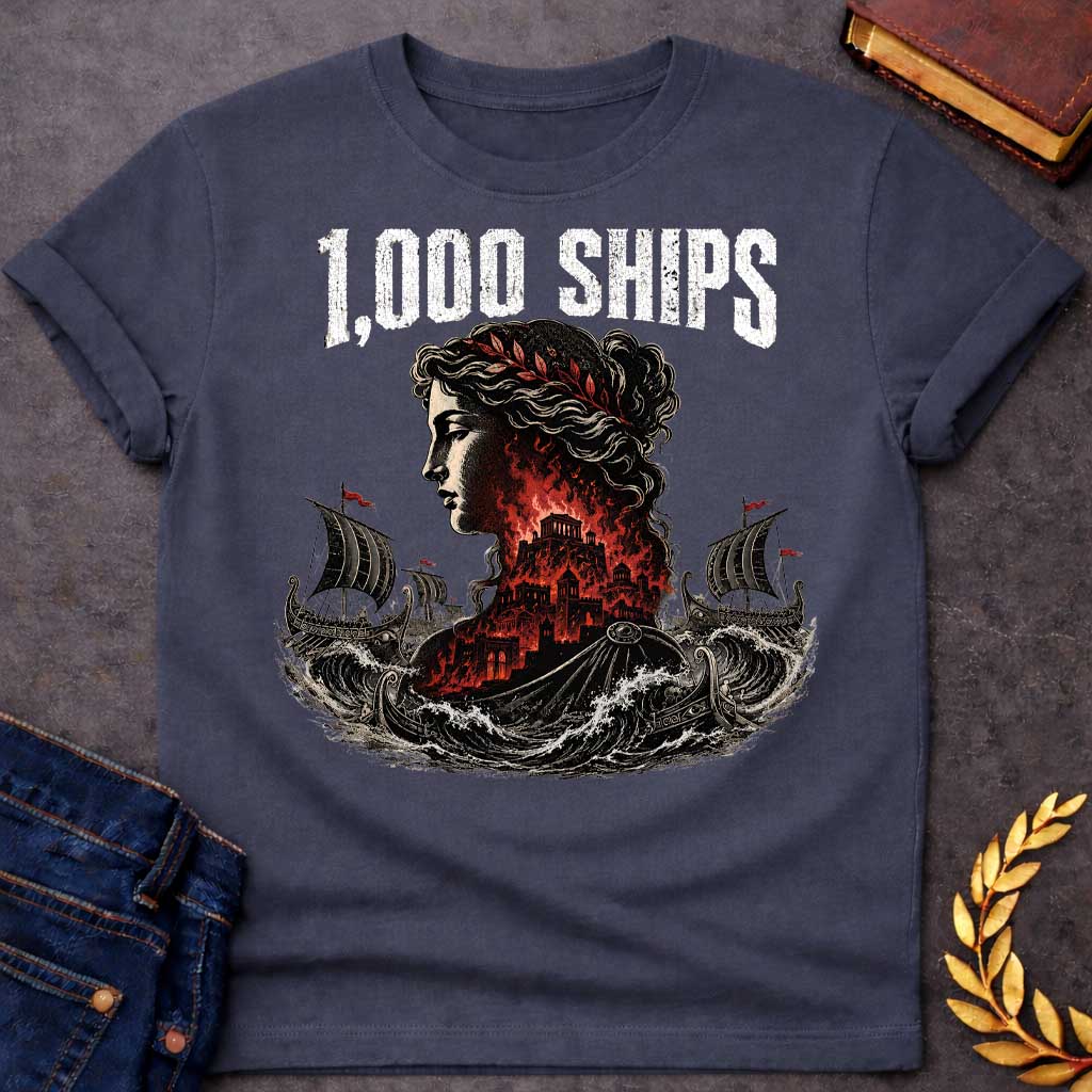 Dark Heather T-shirt with a dramatic illustration of Helen of Troy in profile with curly hair and red laurel crown. Her silhouette contains the burning city of Troy in red and black flames. Greek warships with red flags sail through turbulent waves on either side. Bold distressed text reads '1,000 SHIPS' above. References the famous phrase 'the face that launched a thousand ships' describing Helen's beauty that sparked the Trojan War.
