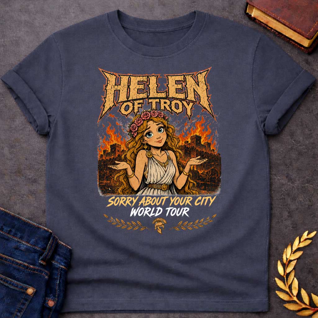 Dark Heather T-shirt with a heavy metal style graphic featuring a cartoon Helen of Troy with big blue eyes and a flower crown. She shrugs playfully while standing in front of a burning ancient city wall. At the top, "HELEN OF TROY" is written in a jagged, metallic font. Below her, the text reads "SORRY ABOUT YOUR CITY" in gold and "WORLD TOUR" in white brush script, accented by a Spartan helmet and laurel leaves.