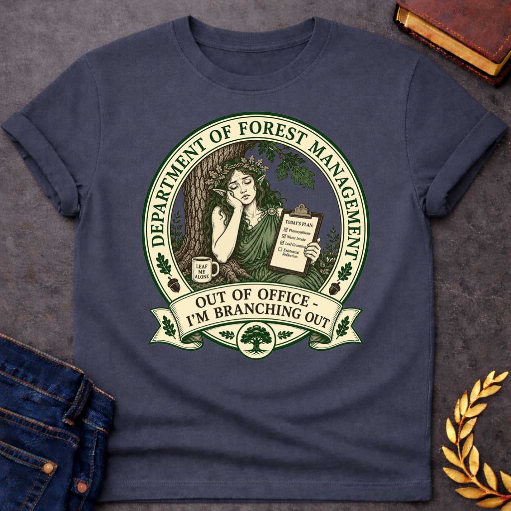 Dark Heather T-shirt with a Humorous official seal depicting a forest goddess managing her day. A woman with long hair and oak leaf crown leans against a tree trunk holding a clipboard listing "Photosynthesis," "Water Intake," "Leaf Grooming," and "Existential Reflection." A mug reads "Leaf Me Alone." Surrounded by oak leaves and acorns. Text reads "Department of Forest Management" and "Out of Office - I'm Branching Out." Green and cream design celebrates nature and forest wisdom.