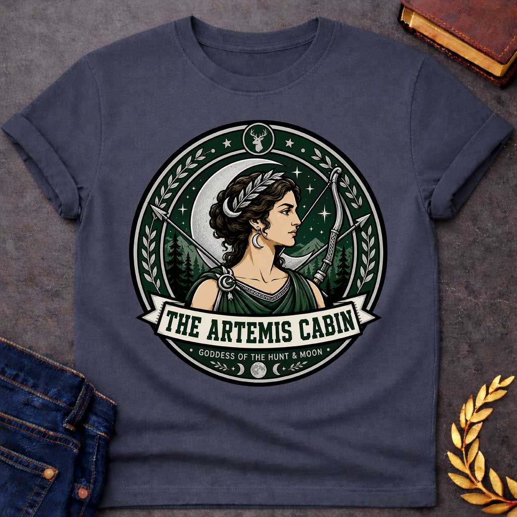Dark Heather t-shirt with a Artemis Greek mythology cabin design featuring the goddess of the hunt and moon with a crescent moon, bow and arrows, forest mountains, stars, laurel branches, and deer symbol. Dark green, silver, cream, and black circular camp-style emblem includes the text “The Artemis Cabin” and “Goddess of the Hunt & Moon.”
