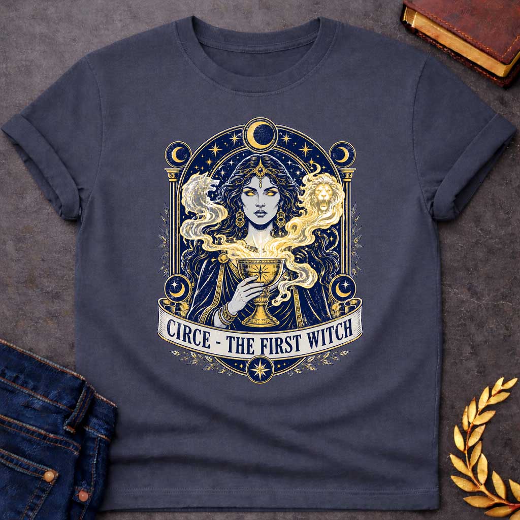 Dark Heather T-shirt with a Mystical tarot-style portrait of Circe, the first witch from Greek mythology, rendered in navy blue and gold. She displays golden glowing eyes and magical hair infused with light energy. Twin lion heads flank her head symbolizing divine power. She holds an ornate golden goblet overflowing with luminous magic. Moon phases in crescent form circle her ethereal figure. Ornate architectural frame with columns and celestial decorations. Gold stars scatter throughout. Banner reads 'Circ