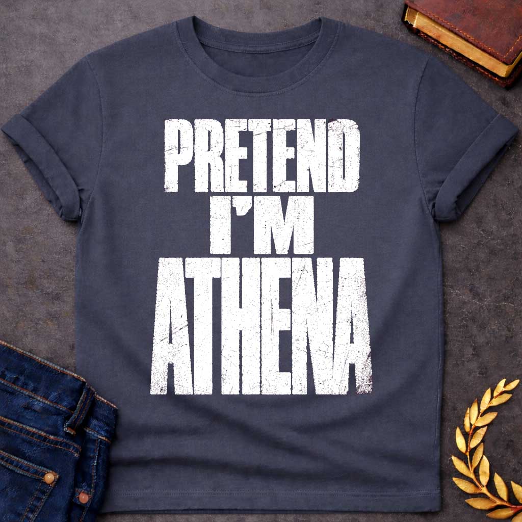 Dark Heather t-shirt with a Pretend I’m Athena Greek mythology design featuring bold distressed white typography on a transparent background. The stacked text reads “PRETEND I’M ATHENA” in a rugged vintage block font, creating a humorous design inspired by Athena, the Greek goddess of wisdom, warfare, strategy, and crafts.