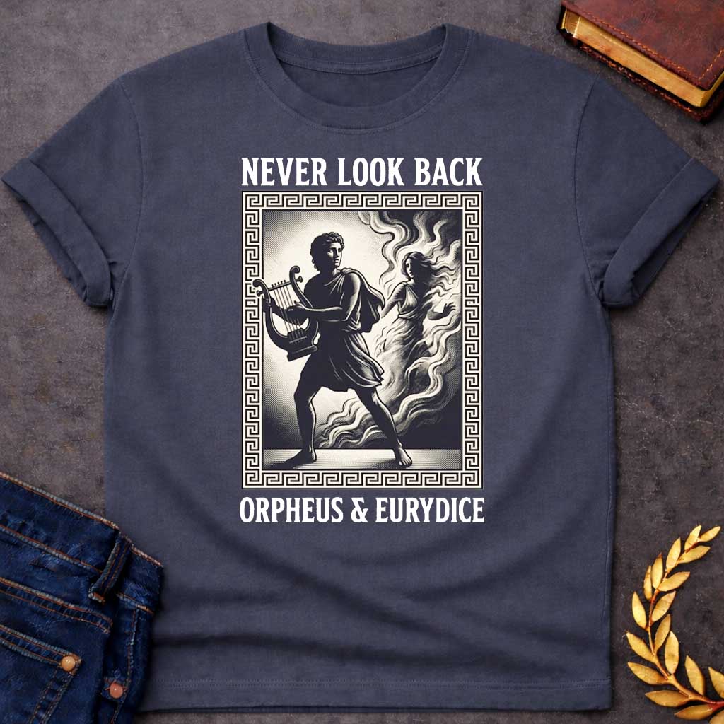Dark Heather t-shirt in engraved woodcut style: Orpheus strides forward carrying a lyre while Eurydice dissolves into smoke and shadow behind him, reaching out. The scene sits within a Greek key-patterned rectangular border, framed by bold serif text above and below, on a cream and black palette.