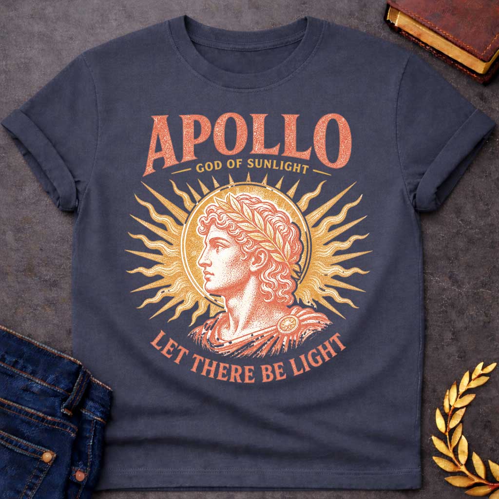 Dark Heather t-shirt with a Vintage Greek mythology design featuring Apollo, god of sunlight, in a classical portrait wearing a laurel crown. A radiant golden sunburst frames the god in warm coral and gold engraving-style artwork. Bold text reads "Apollo – God of Sunlight" and "Let There Be Light," celebrating the legendary Olympian god.