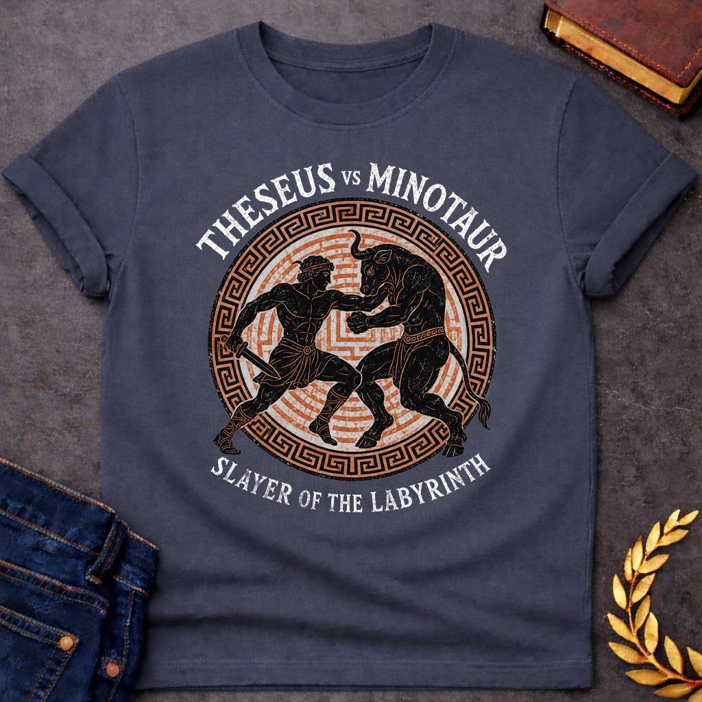 Dark Heather T-shirt with A vintage, Greek pottery-style graphic depicting a battle. At the center, the muscular hero Theseus holds a sword as he wrestles the powerful Minotaur. The black figure silhouettes are set against an orange labyrinth pattern inside a circular frame with a Greek key border. Distressed text reads "THESEUS VS MINOTAUR" arched across the top and "SLAYER OF THE LABYRINTH" curved along the bottom.