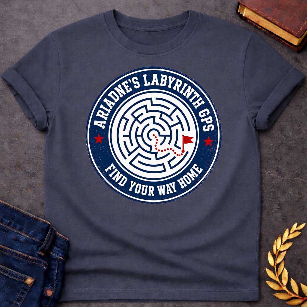 Dark Heather T-shirt with A Circular emblem with concentric maze in navy and white, featuring a red dotted path through the labyrinth toward a flag marker. Red stars accent the design. Text reads 'Ariadne's Labyrinth GPS' around the border and 'Find Your Way Home' below. Merges Greek mythology with modern GPS technology, presenting the legendary thread as contemporary guidance. Celebrates finding home through challenging mazes.
