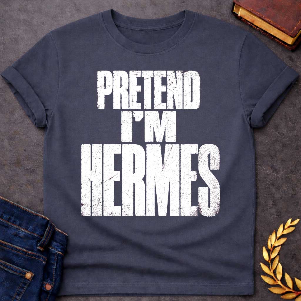 Dark Heather t-shirt with a Pretend I’m Hermes Greek mythology  design featuring bold distressed white typography on a transparent background. The stacked text reads “PRETEND I’M HERMES” in a rugged vintage block font, creating a humorous design inspired by Hermes, the Greek god of travel, messengers, trade, and trickery.