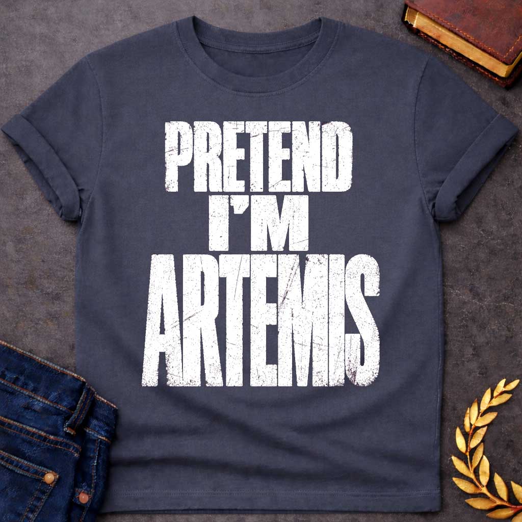 Dark Heather t-shirt with a Pretend I’m Artemis Greek mythology design featuring bold distressed white typography on a transparent background. The stacked text reads “PRETEND I’M ARTEMIS” in a rugged vintage block font, creating a humorous design inspired by Artemis, the Greek goddess of the hunt, wilderness, wild animals, archery, and the moon.