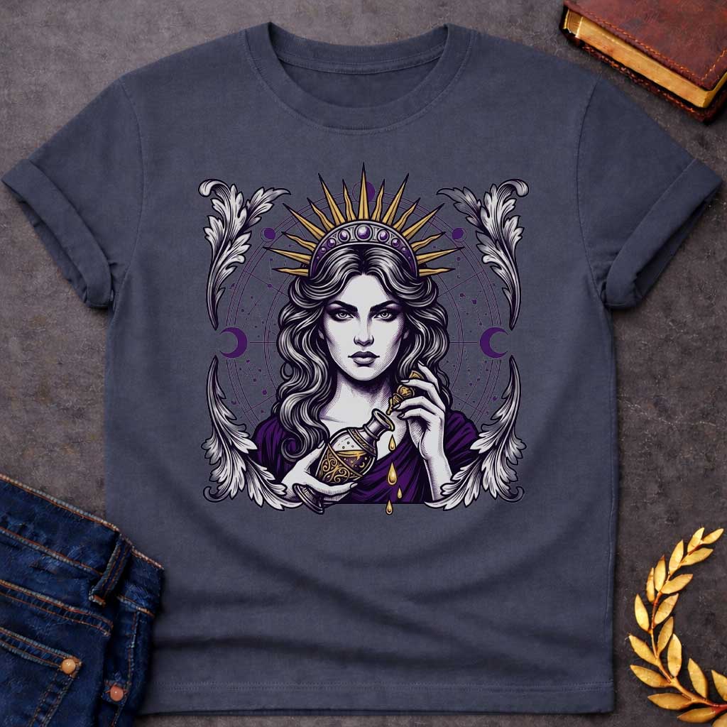 Dark Heather T-shirt with a Mystical portrait of Medea rendered in black, purple, and gold holding an ornate potion vessel with glowing liquid dripping downward. Elaborate celestial backdrop features a radiating golden sun crown, purple moon phases, and astrological constellation patterns surrounding her face. Ornate white wing designs frame the composition. Intricate occult aesthetic celebrates the legendary Greek sorceress's magical power, ancient wisdom, and mystical enchantment.