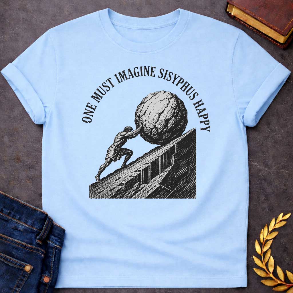 Light Blue T-Shirt with a high-contrast, black-and-white graphic design. The illustration features a woodcut-style depiction of Sisyphus straining to push a massive, craggy boulder up a steep, jagged mountainside. Arched in a bold, weathered serif font over the top of the illustration is the text "ONE MUST IMAGINE SISYPHUS HAPPY,"