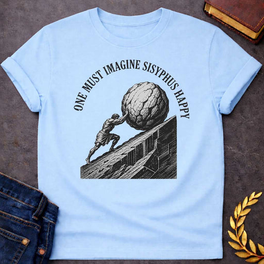 Light Blue T-Shirt with a high-contrast, black-and-white graphic design. The illustration features a woodcut-style depiction of Sisyphus straining to push a massive, craggy boulder up a steep, jagged mountainside. Arched in a bold, weathered serif font over the top of the illustration is the text "ONE MUST IMAGINE SISYPHUS HAPPY,"