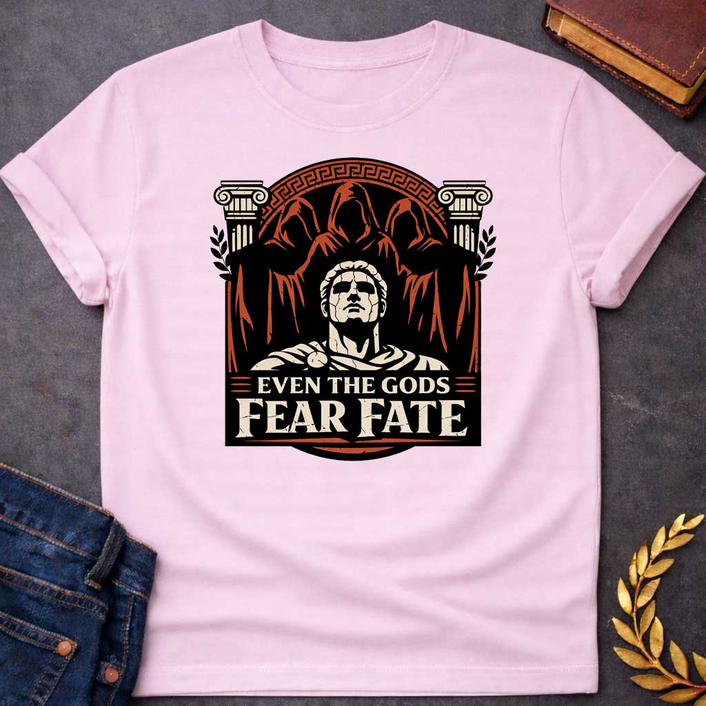 Light Pink shirt featuring a striking graphic design with a classical Greek aesthetic. In the center, a cracked marble bust of a Roman figure gazes upward, flanked by two Ionic columns. Looming behind the statue are three shadowy, hooded figures representing the Fates. The scene is enclosed in a circular Greek key border. The color palette is a bold trio of cream, burnt orange, and black. Below the art, the text reads "EVEN THE GODS" in a clean serif font and "FEAR FATE" in large, distressed block letters