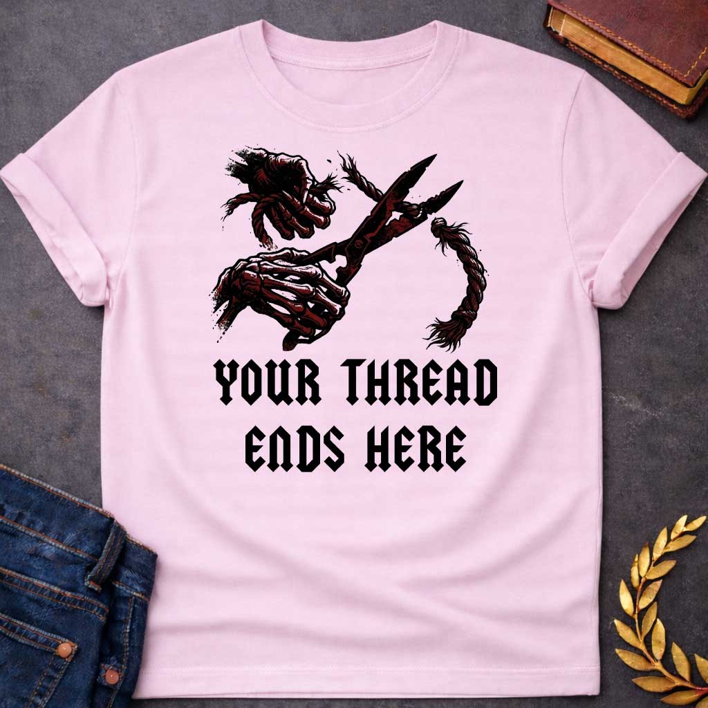 Light Pink T-shirt graphic in black, white, and dark red featuring a dark illustrated scene of two skeletal hands gripping large shears cutting through a thick fraying rope or thread, rendered in a gritty horror-influenced ink style with ink splatter details. Bold heavy metal-style blackletter text below reads "Your Thread Ends Here" — a dark and dramatic reference to Atropos, the eldest of the Moirai, the Greek Fate who cuts the thread of life