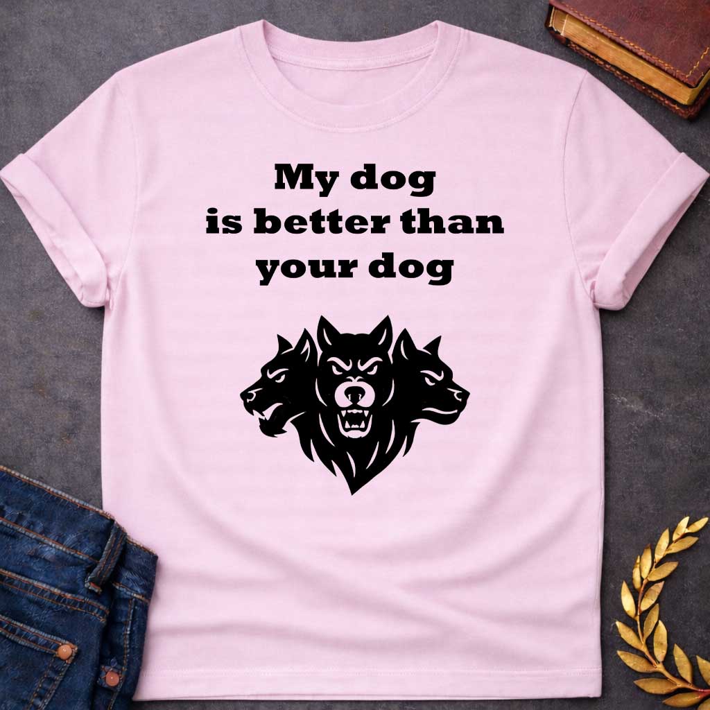 Light Pink T-shirt graphic in black and white featuring bold serif text reading "My dog is better than your dog" above a flat black silhouette illustration of Cerberus, the three-headed dog of the underworld, with the center head facing forward snarling and the two side heads in profile, in a humorous nod to Hades from Greek mythology, designed for a light-coloured shirt
