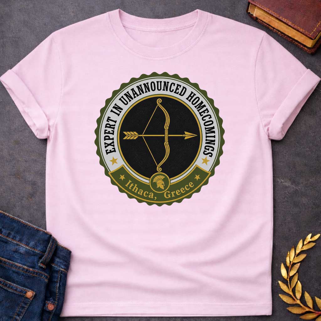 Light Pink T-shirt with a graphic featuring a vintage military challenge coin-style badge design in olive green, black, gold, and white. A golden bow and arrow are centered on a black background within the circular badge, with text arched around the outer ring reading "Expert in Unannounced Homecomings" flanked by gold stars. A green ribbon banner at the bottom features a Spartan helmet medallion and reads "Ithaca, Greece" with gold stars — a humorous reference to Odysseus, the hero of Homer's Odyssey who f