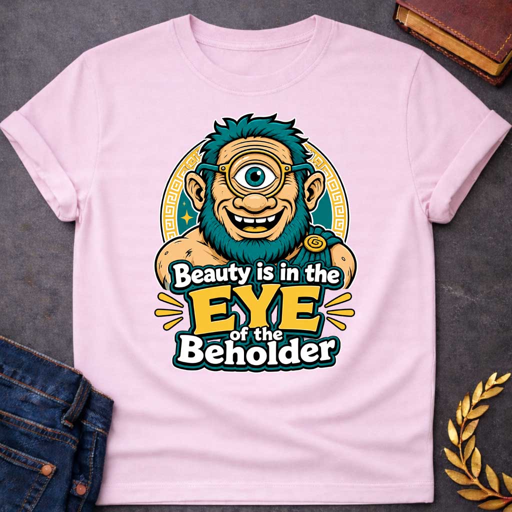 Light Pink T-shirt with a Humorous graphic design featuring a cheerful creature with exaggerated facial features inspired by Argus Panoptes, the many-eyed giant from Greek mythology. A large teal eye with a golden monocle dominates the character's smiling face. Teal spiky hair and beard contrast with peachy skin tones. Greek key pattern borders frame the design in gold and teal. Text reads 'Beauty is in the Eye of the Beholder' in bold white and yellow lettering. Playful visual pun celebrating perspective.