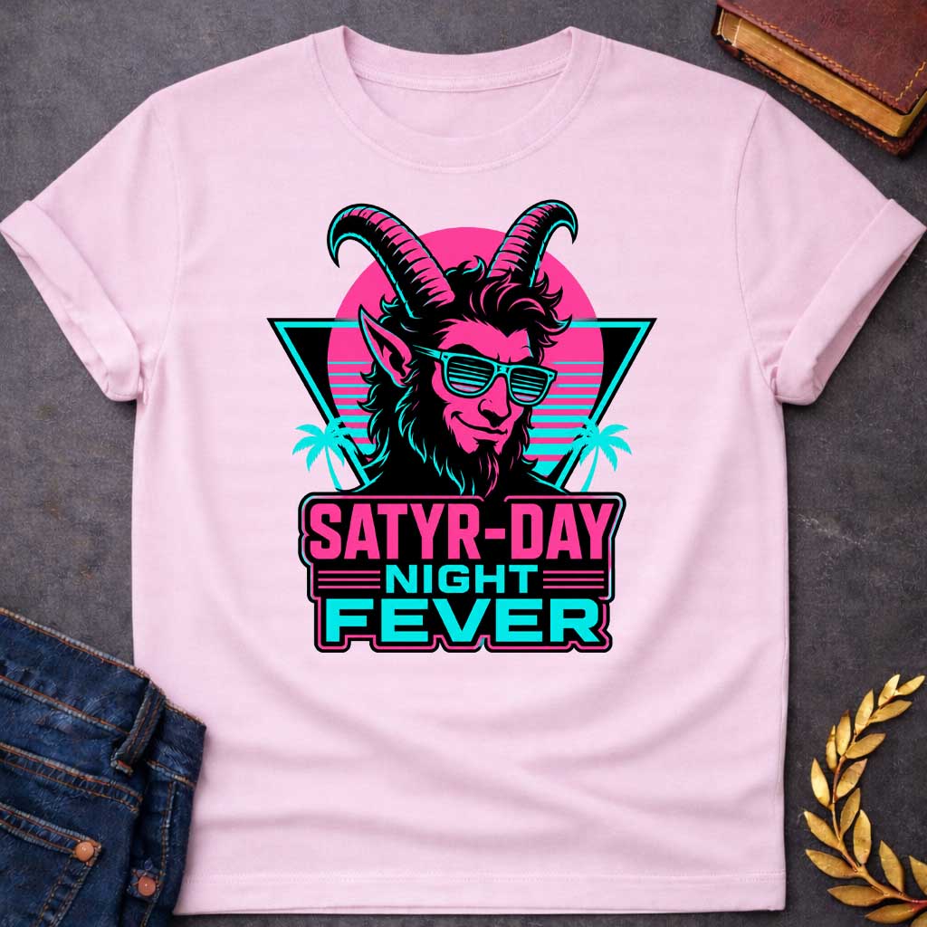 Light Pink T-shirt with a vibrant 1980s synthwave-style graphic for "satry-day night fever.jpg". It features a cool satyr with large horns, a smirk, and cyan shutter shades, illuminated in neon pink and black. The background shows a retrowave sunset grid, a black triangle, and palm trees. Below, the punny title "SATYR-DAY NIGHT FEVER" is displayed in bold neon pink and cyan block lettering against a dark badge