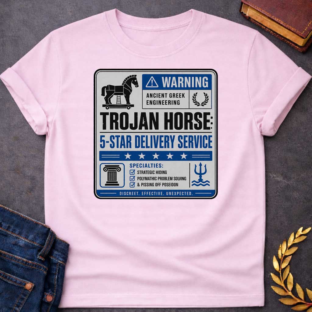 Light Pink T-shirt with a graphic designed as a humorous official-style warning sign in grey, blue, and black featuring a flat Trojan Horse icon with a blue warning triangle and the text "Warning — Ancient Greek Engineering" and a laurel wreath in the top section. Bold text reads "Trojan Horse: 5-Star Delivery Service" above a blue five-star rating banner. A checklist below under "Specialties:" reads "Strategic Hiding, Polymathic Problem Solving, & Pissing Off Poseidon" flanked by a Greek column icon and a