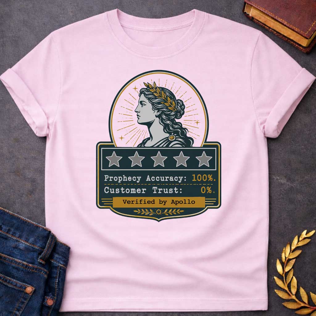 Light Pink T-shirt with a satirical Greek mythology badge referencing Cassandra. The top features a vector profile of a woman wearing a gold laurel wreath with a radiant sunburst behind her. Below, a dark plaque displays five empty review stars. The text reads: "Prophecy Accuracy: 100%." and "Customer Trust: 0%." in a typewriter font. A gold banner at the bottom is stamped with "Verified by Apollo."