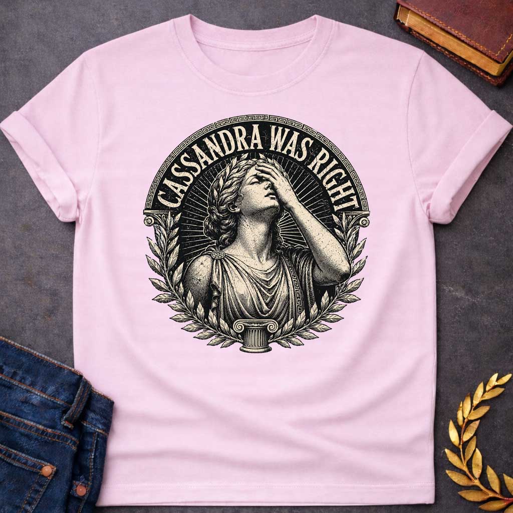 Light Pink T-shirt with a classical engraving-style illustration of Cassandra, the Trojan prophetess, looking upward with one hand raised to her forehead in anguish. She wears flowing Greek robes with decorative brooch and Greek key pattern trim. Surrounded by laurel wreaths and flanked by Ionic columns. Radiating lines create a dramatic halo effect. Text 'CASSANDRA WAS RIGHT' curves along the top within a Greek key border. References the tragic myth of Cassandra, cursed to see the future but never be belie