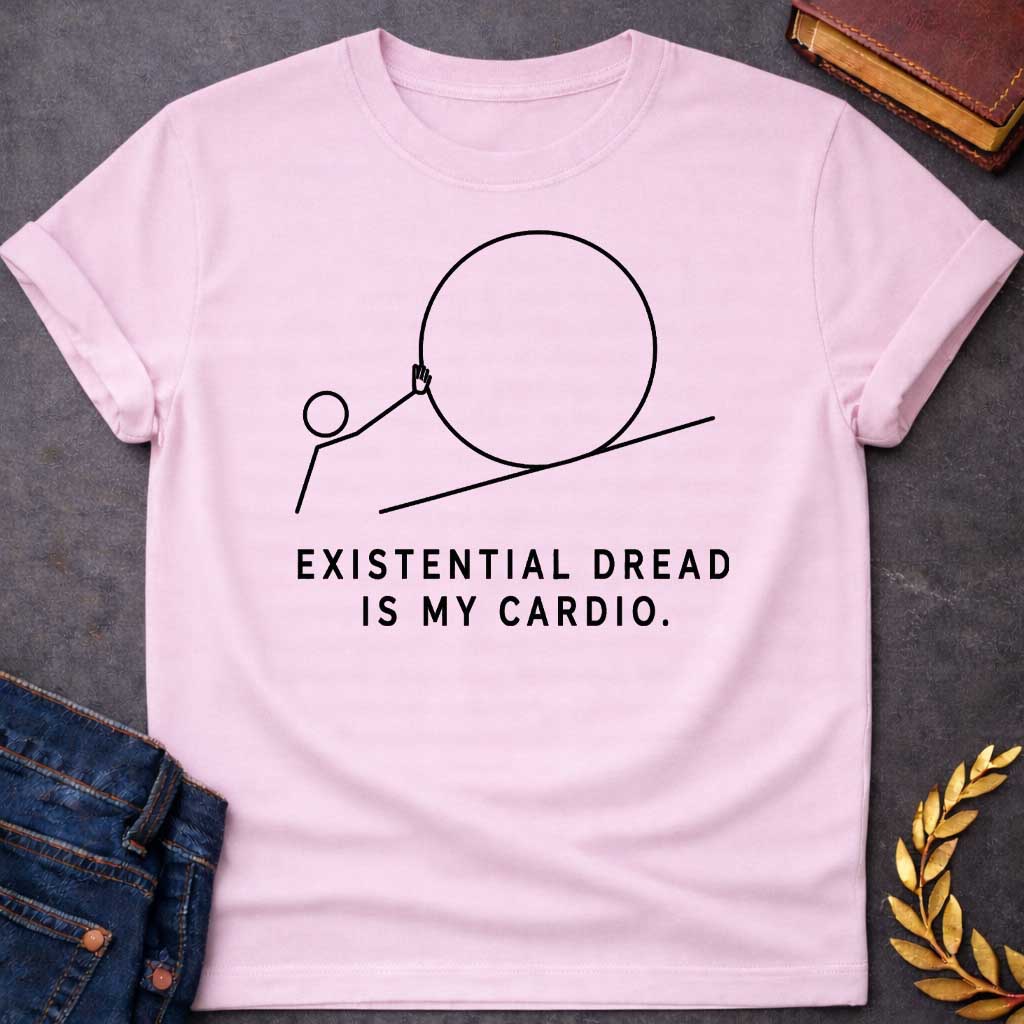 Light PInk T-Shirt with a minimalist black graphic design. It features a simple line-art illustration of a stick figure pushing a large circle up a diagonal line, depicting a humorous take on the myth of Sisyphus. Below the illustration, the black text reads: "EXISTENTIAL DREAD IS MY CARDIO."