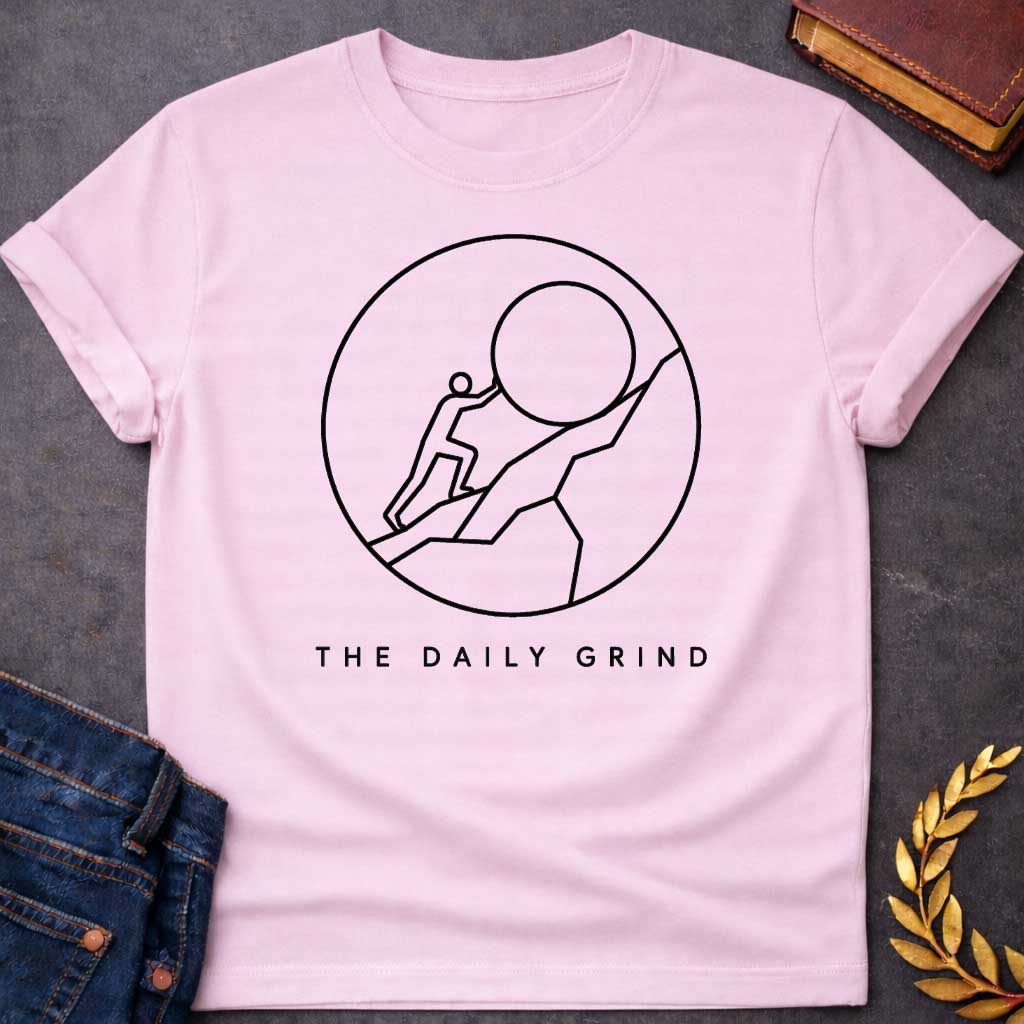 Light Pink T-Shirt with a minimalist black graphic design.  Inside a thin circle is a simple line-art illustration of a stick figure pushing a large boulder up a steep hill, representing the myth of Sisyphus. Below the circle, the text reads "THE DAILY GRIND" in a clean, sans-serif font.