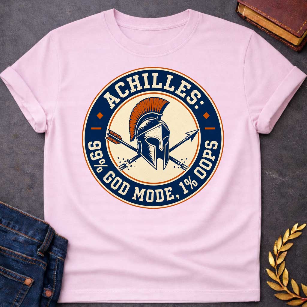 Light Pink T-Shirt with a circular badge design in navy blue, cream, and burnt orange featuring a Greek Corinthian helmet with orange horsehair crest, crossed by two arrows. Styled like a vintage achievement badge. Text reads 'ACHILLES:' at top, '99% GOD MODE, 1% OOPS' at bottom. Humorously references Achilles and his famous vulnerability—his heel—suggesting he was nearly invincible (99% in 'god mode') except for one fatal weakness (1% 'oops'). Distressed, retro aesthetic mimics vintage sports or gaming bad