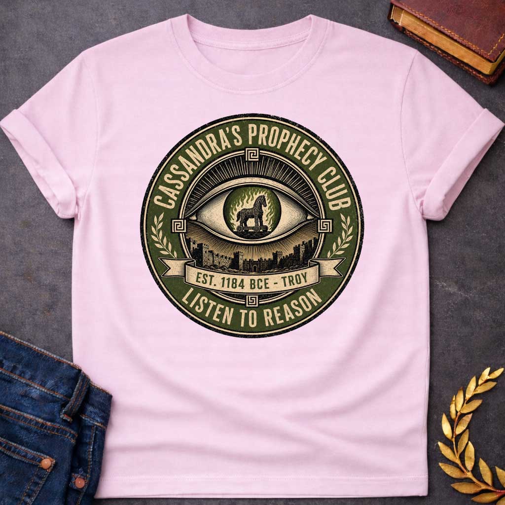 Light Pink T-shirt with a Vintage circular badge in olive green, cream, and black featuring an all-seeing eye at center with the Trojan Horse surrounded by flames in the pupil. Below the eye are the walls of Troy. Text reads 'CASSANDRA'S PROPHECY CLUB' around the top arc, 'EST. 1184 BCE - TROY' on a banner, and 'LISTEN TO REASON' along the bottom. Wheat sheaves and Greek key patterns decorate the sides. Distressed texture. References Cassandra's ignored warnings about the Trojan Horse.